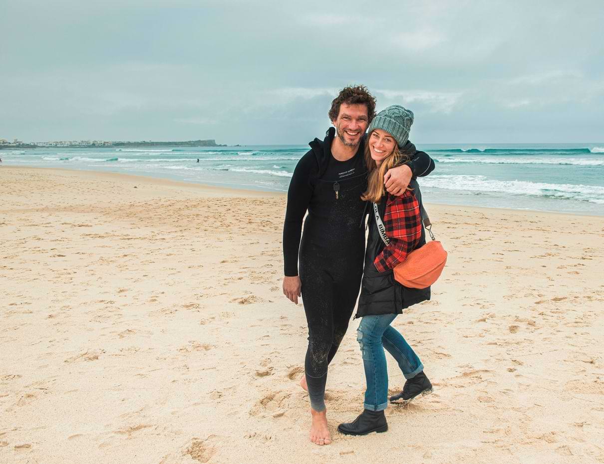about Couple embracing on sandy beach with ocean backdrop