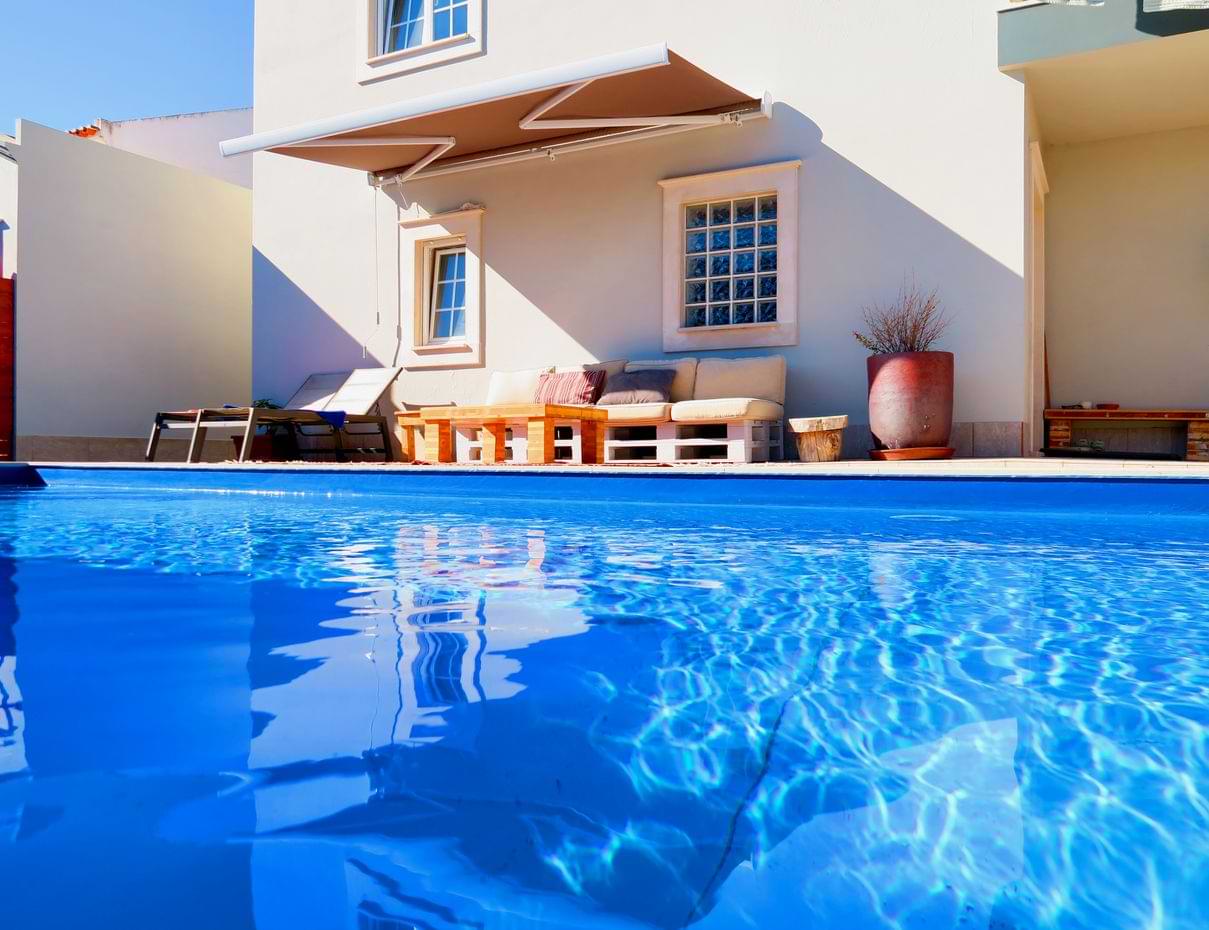 chillax-villa Sunny poolside house with seating and open umbrella