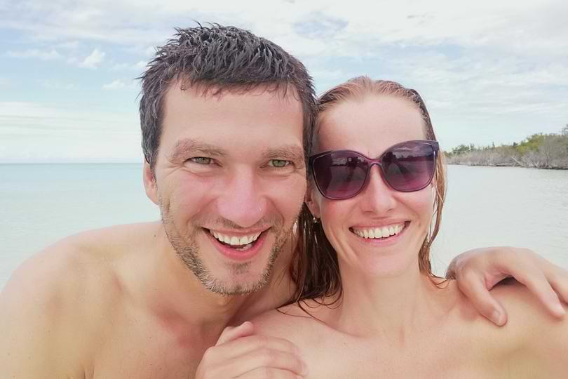 reviews-our team Joyful couple taking selfie on tropical beach