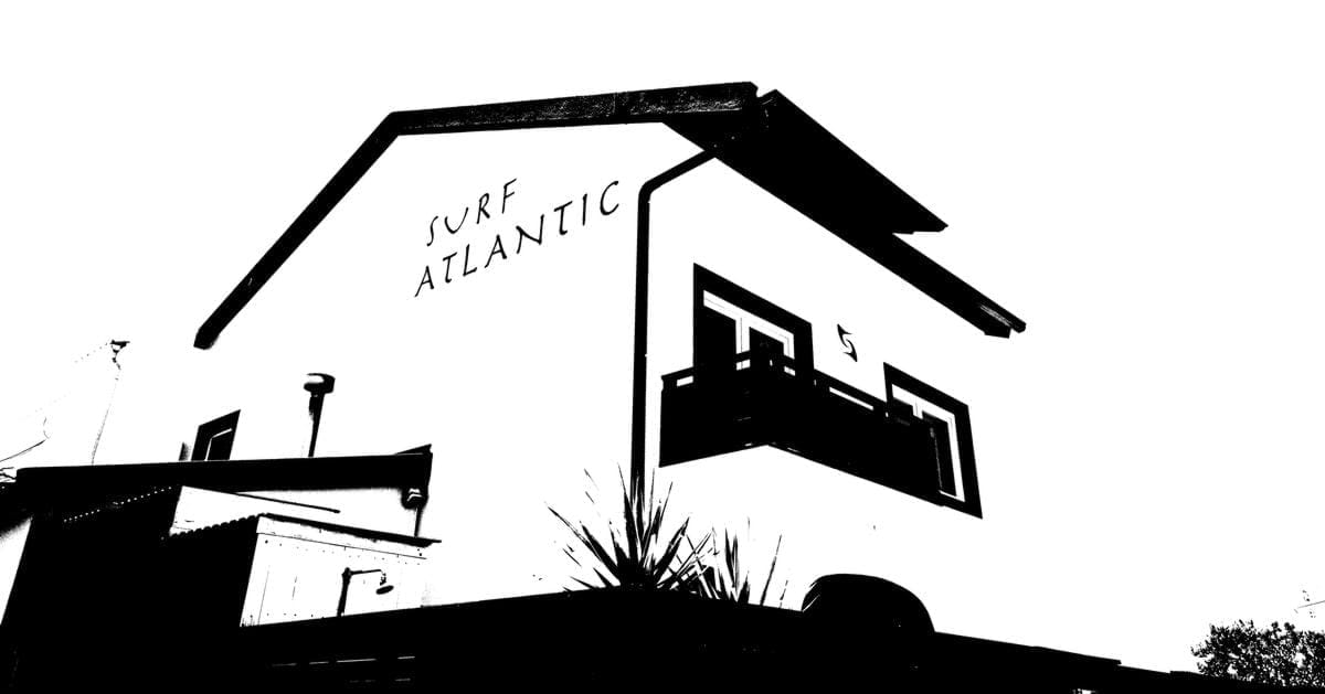 High-contrast black and white architectural view of the Surf Atlantic building exterior and logo.