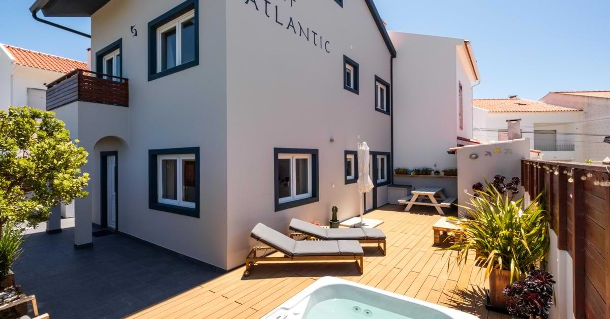 Exterior view of Surf Atlantic surf house rental in Baleal, Peniche featuring a private wooden deck and hot tub.