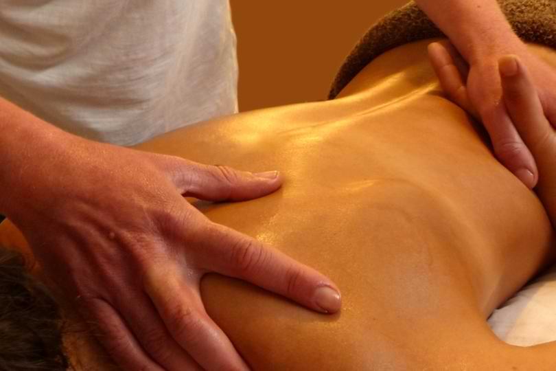 Relaxing Surf Holiday Massage Services Close-up of a deep tissue massage therapy session focusing on upper back relaxation.